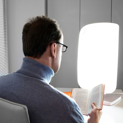 „Medizinischer Gutachter liest Fachliteratur zur Begutachtung vor einer Lichttherapielampe, symbolisiert die Integration wissenschaftlicher Grundlagen in medizinischer und juristischer Gutachtenstellung. - © PhotoSG - stock.adobe.com