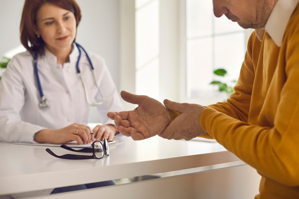 „Ein Gutachter im medizinischen Fachgespräch mit einem Patienten, um den Schmerz bei einer Handerkrankung detailliert zu bewerten und die Grundlage für eine juristische Beurteilung im Versicherungsfall zu schaffen.“. - © Studio Romantic - stock.adobe.com
