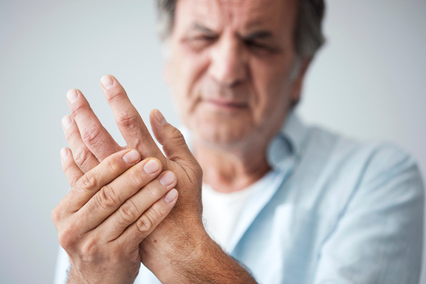 Älterer Mann hält seine Hand mit einem schmerzvollen Ausdruck; Symbolisiert mögliche Fallbeispiele für medizinische Begutachtung und versicherungsmedizinische Fragestellungen. - © sebra - stock.adobe.com