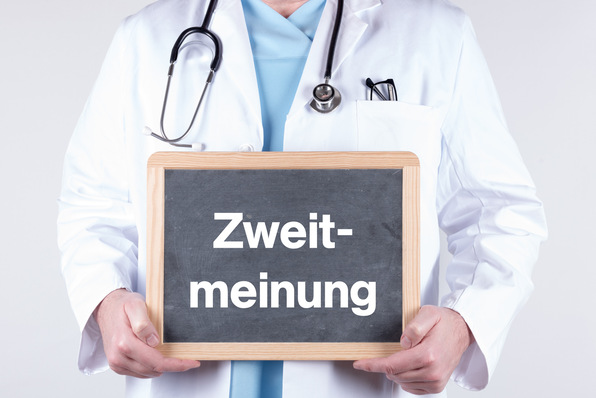 Medizinischer Gutachter in weißem Kittel mit Stethoskop zeigt ein Schild mit der Aufschrift 'Zweitmeinung', symbolisiert die Bedeutung von Zweitmeinungen bei medizinischen Begutachtungen im Kontext von Rechtsprechung und sozialmedizinischen Fragestellungen. - © HNFOTO - stock.adobe.com